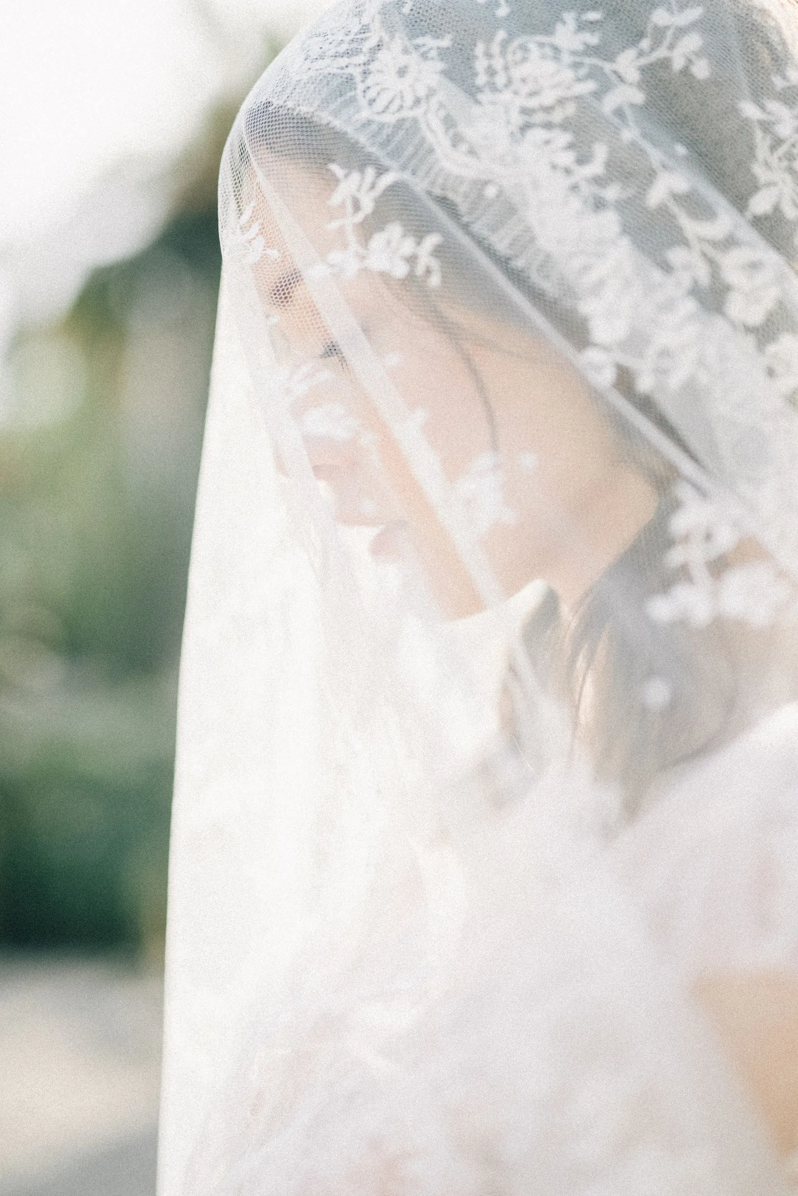 A bride under a veil of embroidered lace